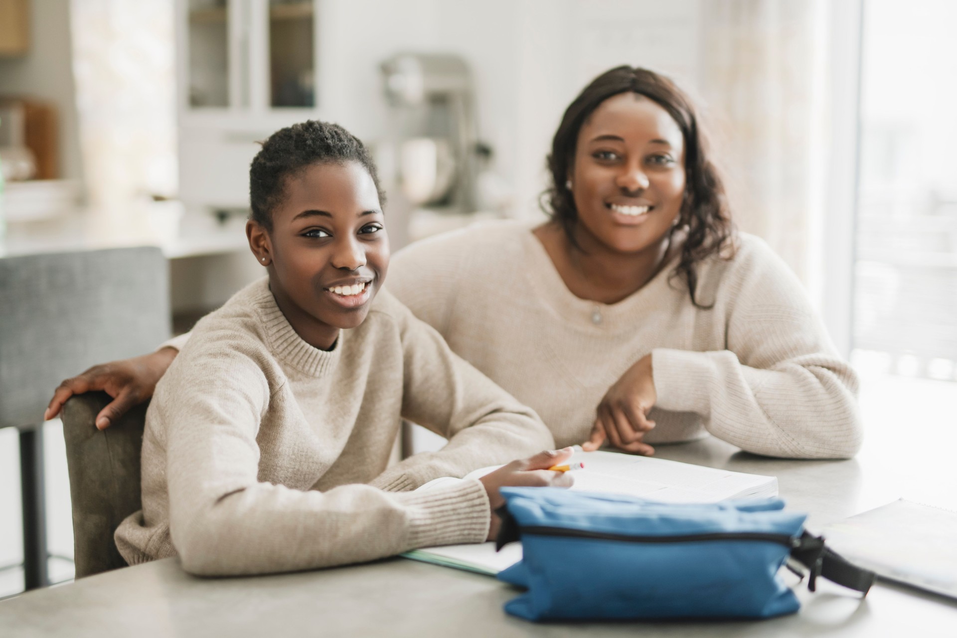 Beautiful woman and her cute little daughter are doing homework